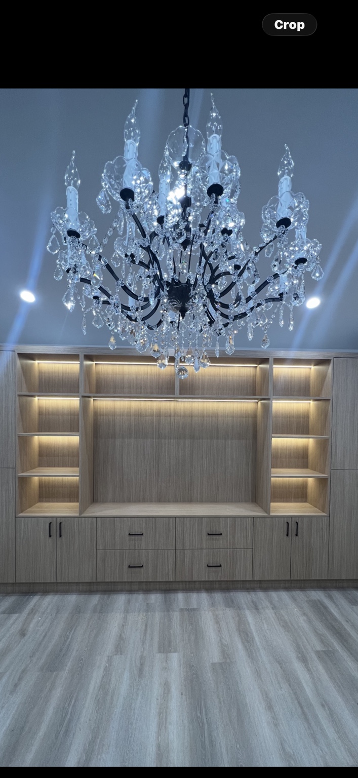 Chandelier and integrated cabinet lighting in a finished room