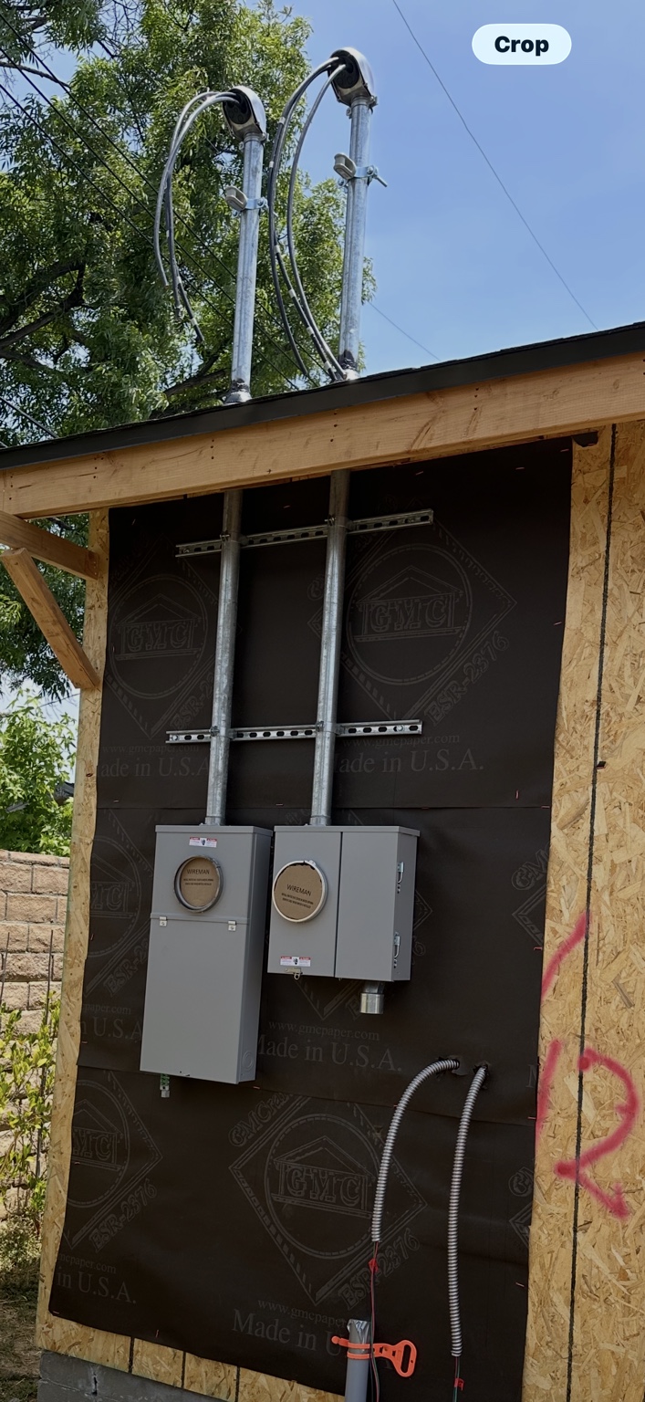 Two meter enclosures and service conduits on a building under construction